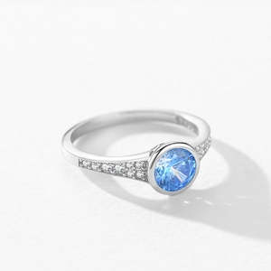 Lussuoso anello in argento S925 con zircone blu tondo e pavé di diamanti laterali