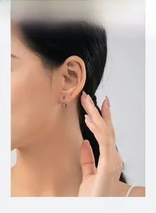 Close-up of s925 silver hoop earring with twisted texture on a female model