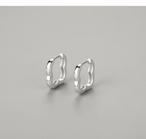Close-up of polished S925 silver earrings with unique wavy petal design on gray background