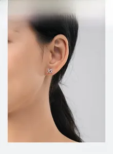Side view of model wearing crossed s925 silver stud earrings with pavé micro-set diamonds