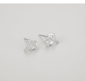 Macro shot of silver knot earrings with micro-pave clear zircons for a shiny finish