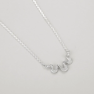 Geometric S925 silver necklace with micro-pave wave pendant on light gray background