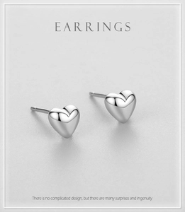 Macro detail of minimalist S925 sterling silver heart stud earrings with polished finish