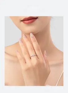 Dettaglio dell'anello a croce in argento S925 con micro-pavé di pietre sulla mano della modella