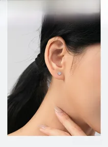Nahaufnahme eines Models mit minimalistischen runden Silberohrsteckern mit Mikro-Kristallen