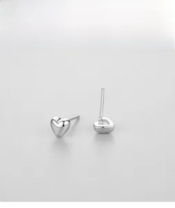 Detail view of heart-shaped S925 sterling silver studs with polished mirror finish surface