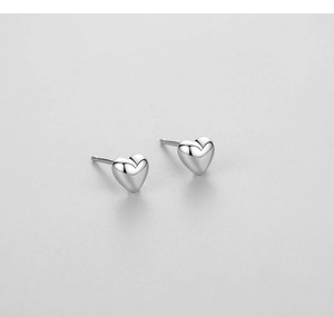 Macro detail of minimalist S925 sterling silver heart studs with polished mirror finish