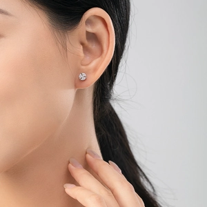 Orecchini a fiore in argento s925 con zirconi bianchi indossati da una modella donna