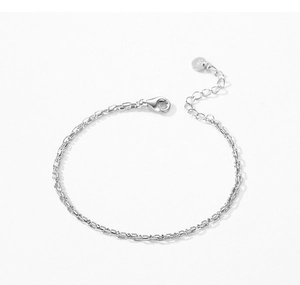 Macro detail of S925 sterling silver stamp on a minimalist double-layer chain bracelet