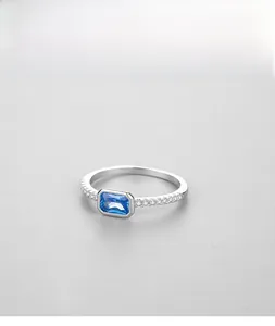 Macro detail of s925 silver ring with rectangular blue gemstone and white zircon accents