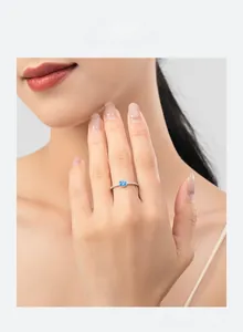 Gros plan d'une bague en argent s925 avec zircon bleu ovale sur le doigt d'un mannequin