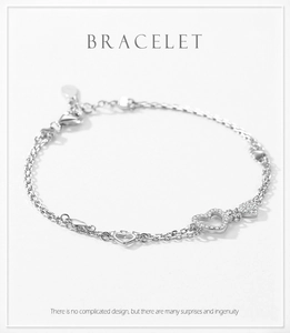 Macro detail of S925 silver heart bracelet featuring micro-pave crystals and dainty chain