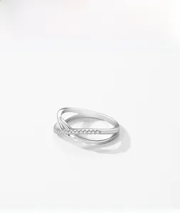 Detail of s925 silver criss-cross ring featuring one polished band and one micro-pave band
