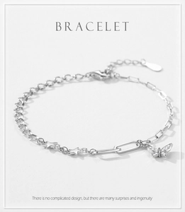 Macro detail of s925 silver butterfly bracelet with pave stones and star pendants