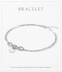 Macro view of geometric S925 silver link bracelet with circular quote pendant and lobster clasp