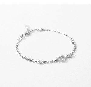 Macro detail of double-layered silver heart bracelet with cubic zirconia paving