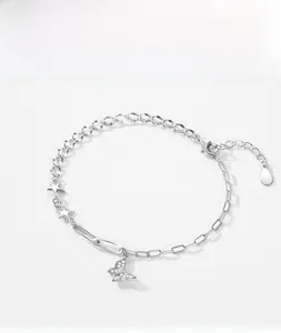 Detail of s925 silver bracelet featuring zircon butterfly and star charms with mixed chain