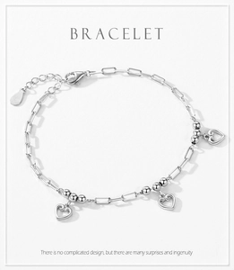 Detailed shot of S925 silver bracelet featuring hollow heart charms and paperclip chain