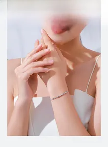 Close-up of a minimalist shimmering s925 silver chain bracelet worn on a woman wrist