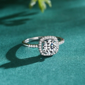 Classic S925 silver halo ring with round main stone and pave settings on green background