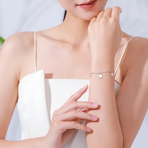 Elegantes S925 Sterling Silber Armband mit runden Anhängern am Handgelenk eines Models