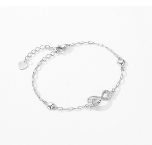 Dettaglio del bracciale infinito in argento s925 con pietre pavé e ciondoli a cuore su bianco