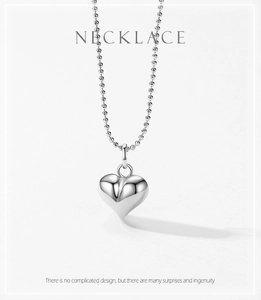 Détail du collier à billes en argent 925 avec pendentif cœur poli sur fond gris clair