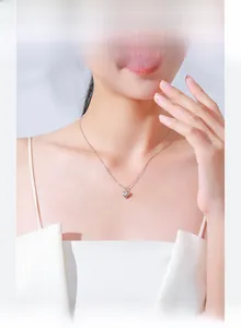 Gros plan d'un collier pendentif coeur en argent S925 sur un modèle avec finition miroir polie