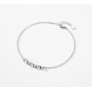 Macro detail of S925 sterling silver geometric bracelet with polished beans and lobster clasp