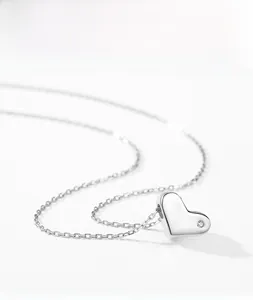 Macro shot of s925 silver heart necklace with a sparkling zircon inlay on white background