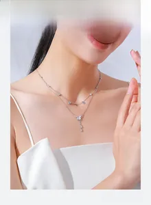 Détail du collier double rang en argent avec pendentif papillon et pampilles élégantes