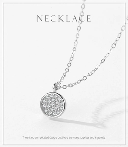 Macro detail of silver S925 necklace featuring a sparkling round paved pendant with white stones