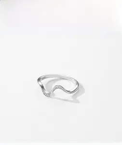 Dettaglio macro dell'anello ondulato in argento sterling S925 con micro-pavé di zirconi