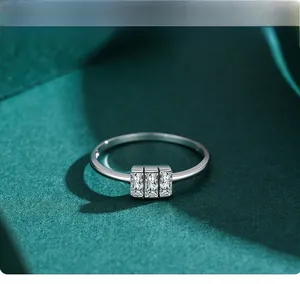 Macro d'une bague en argent sertie de trois pierres moissanites sur velours vert foncé