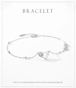 Close-up of S925 sterling silver chain bracelet with LOVE engraved heart and zircon stone