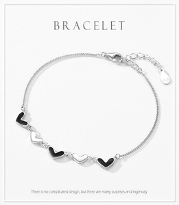 Détail macro du bracelet en argent sterling S925 avec cinq breloques cœurs noirs et mousqueton