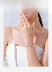 Close-up of S925 sterling silver heart bracelet with sparkling zircon on woman's wrist