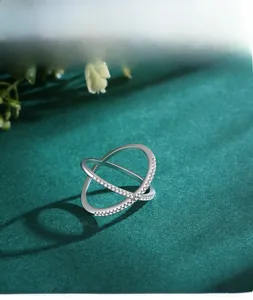 Macro detail of S925 sterling silver X-shaped criss-cross ring with sparkling zircons