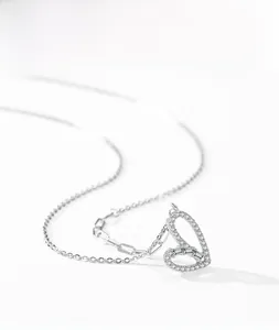 Gros plan du collier coeur en argent S925 avec zircons pavés et détail de chaîne épingle