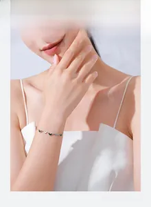 Détail du bracelet en argent s925 avec cœurs en émail noir et blanc sur un poignet féminin