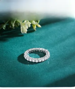 Macro view of S925 sterling silver eternity ring with round-cut pavé diamonds on green velvet