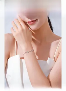 Macro shot of silver clover bracelet with cubic zirconia on model wrist
