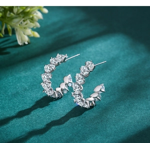 Macro shot of S925 silver U-shaped hoop earrings with pear-cut cubic zirconia stones