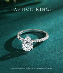 Vue détaillée de la bague en diamant poire avec anneau en argent pavé sur fond vert
