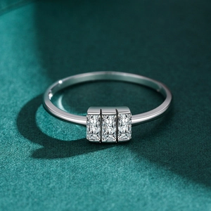 Bague en argent S925 avec trois diamants de coupe rectangulaire sur fond vert foncé
