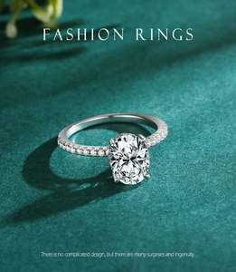 Macro detail of oval cut faux diamond ring with four-prong setting on green background