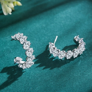 Elegant S925 silver C-shape earrings with pear-cut cubic zirconia on green velvet