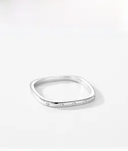 Detail of silver square ring featuring five sparkling white zircons on a thin band