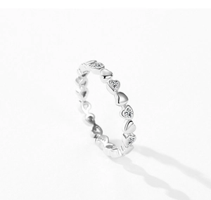 Détail macro d'une bague en argent S925 avec cœurs entrelacés sertis de zircons cubiques