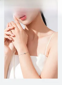 Détail d'un bracelet en argent sterling S925 avec cœur au poignet, style minimaliste